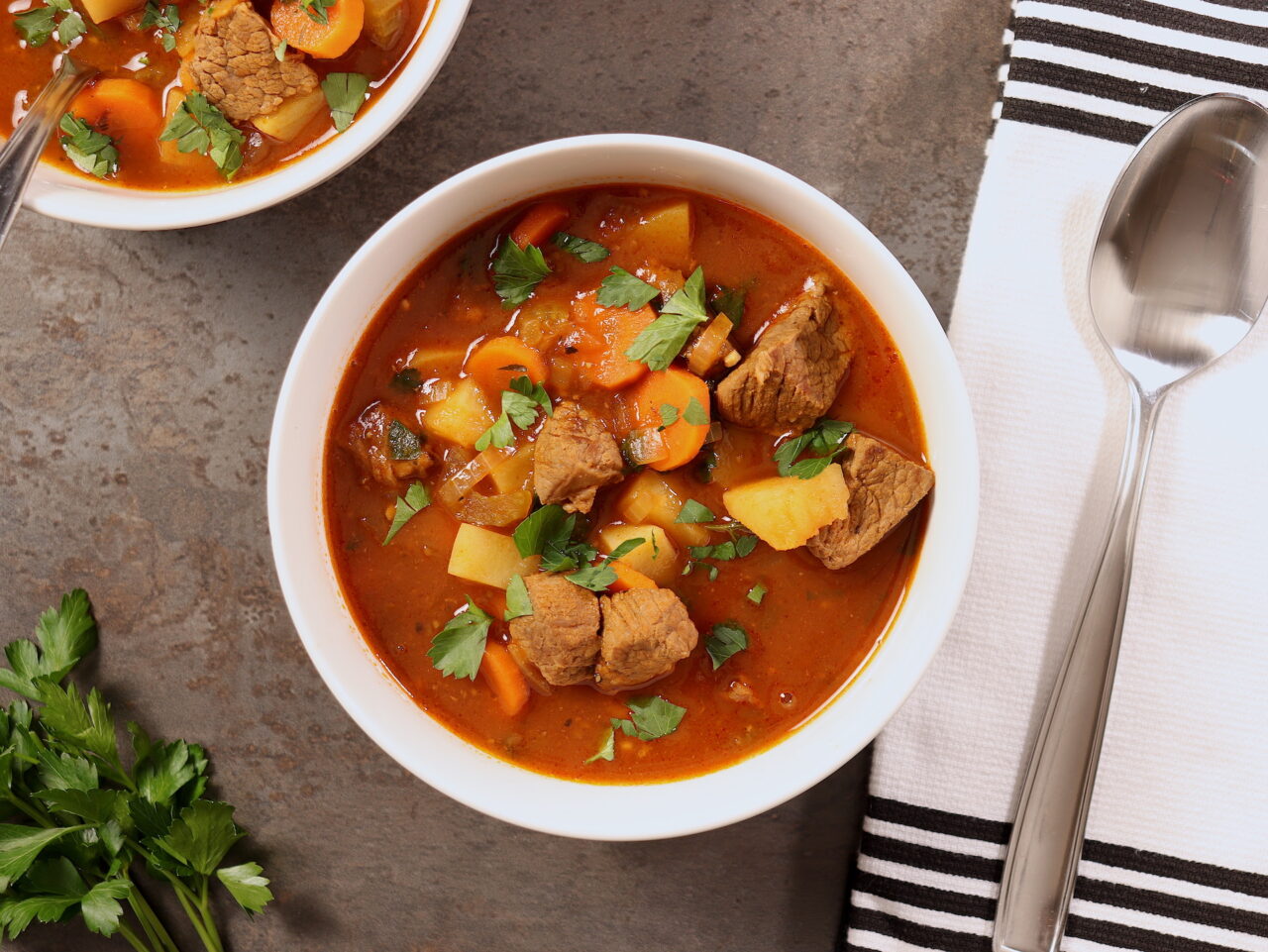 A hearty bowl of homemade vegetable beef soup, brimming with colorful vegetables and tender chunks of beef, promising a comforting and nutritious meal."