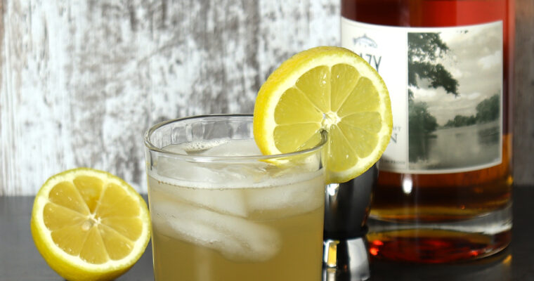 Refreshing whiskey lemonade cocktail in a rocks glass and garnished with a slice of lemon.