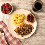 Crispy skillet breakfast potatoes served with scrambled eggs, English muffin, strawberries and coffee.