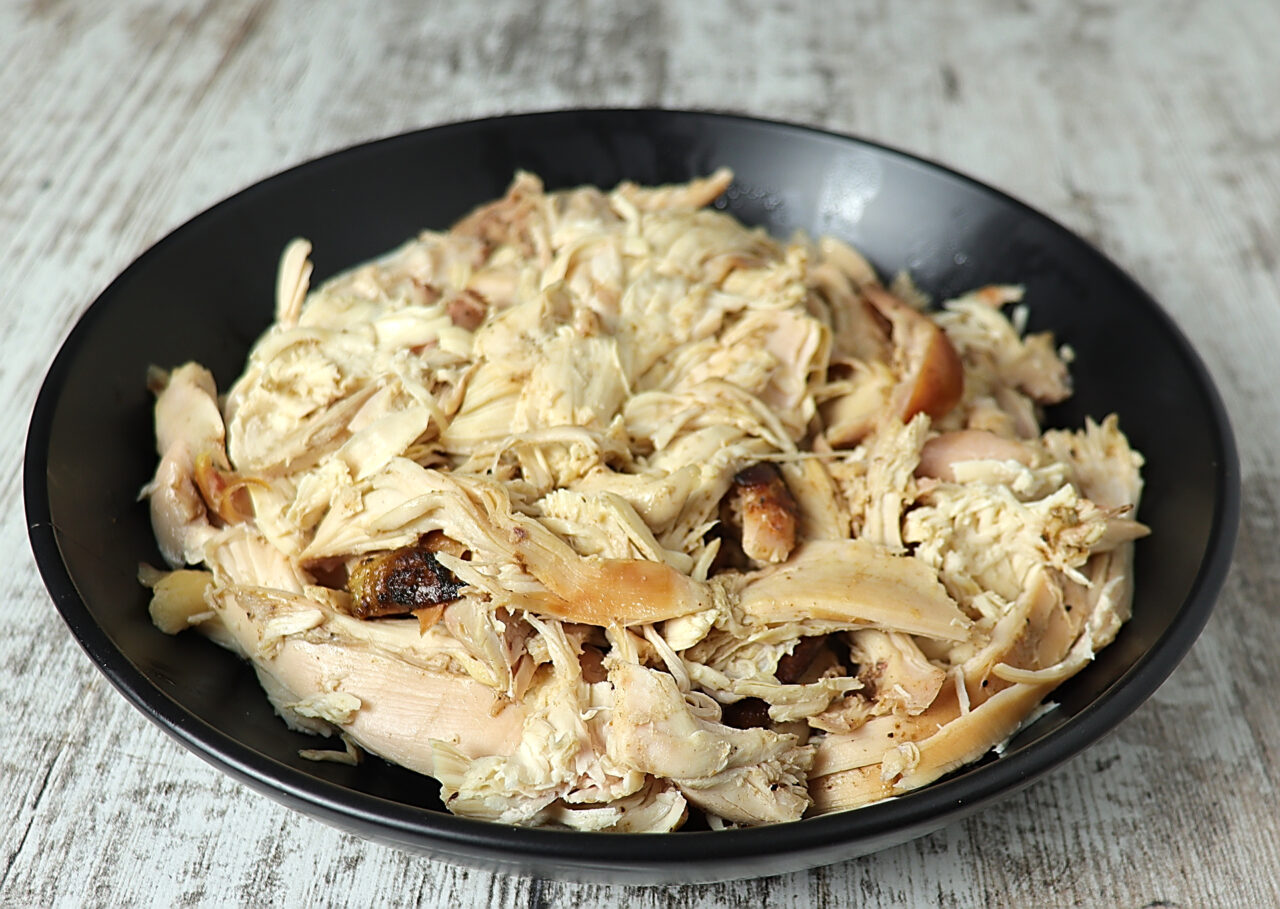 A heaping dish of tender smoked pulled chicken.