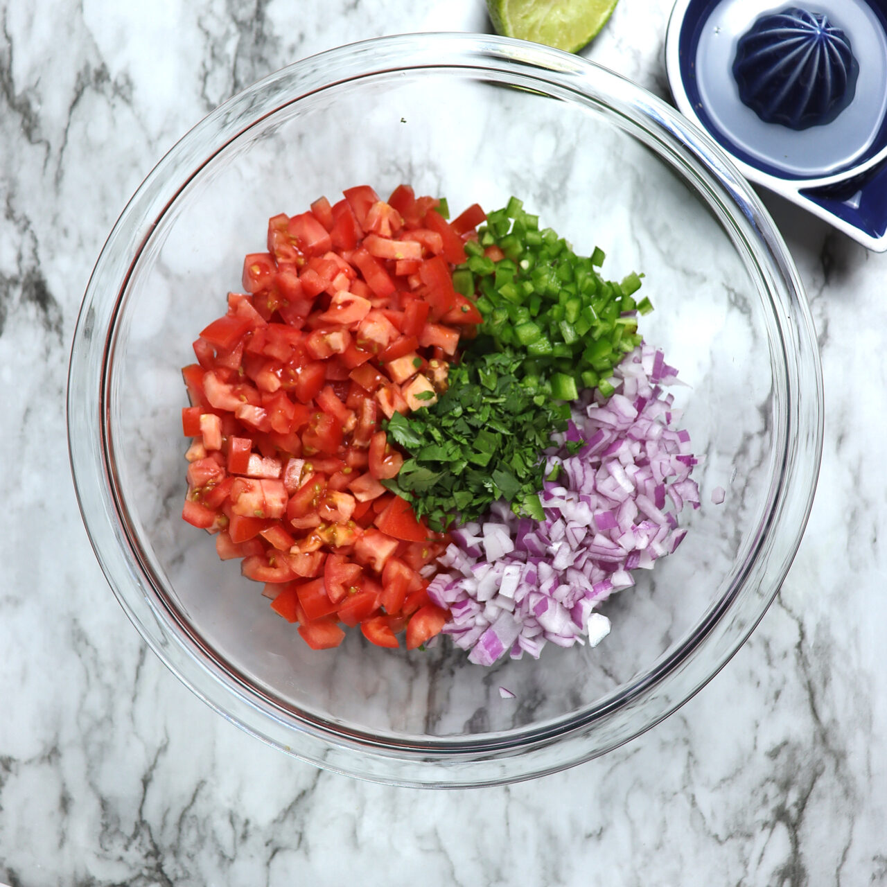 Bowl of Pico de Gallo ingredients, including chopped Roma tomato, red onion, jalapeño, cilantro, and lime juice.