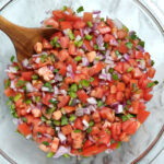 A bowl of classic Pico de Gallo mixed with chopped Roma tomatoes, jalapeño, red onion, cilantro and squeezed lime.