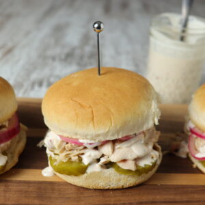 spicy smoked pulled chicken sandwich with Alabama White Sauce, pickles and Red Onions.