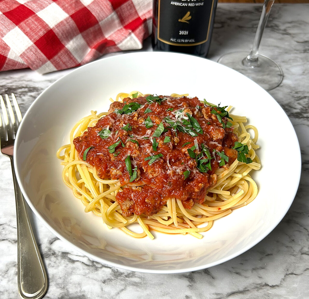 Bowl of spaghetti meat sauce over spaghetti noodles.