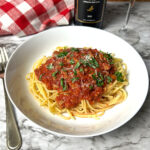 Bowl of spaghetti meat sauce over spaghetti noodles.