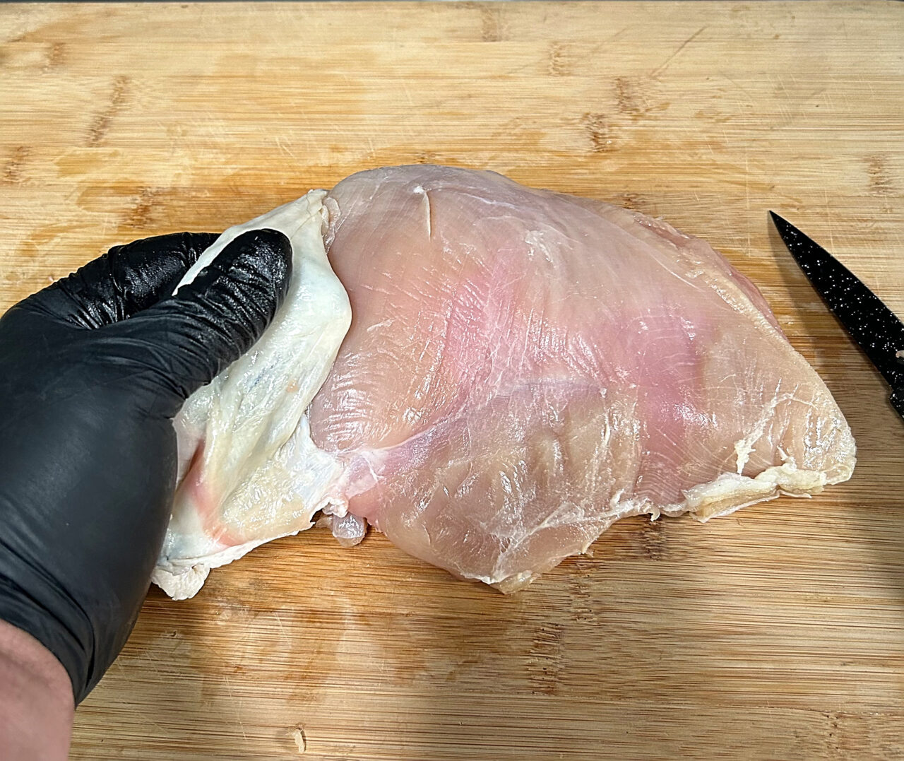 Trimming the skin off a larger turkey breast.