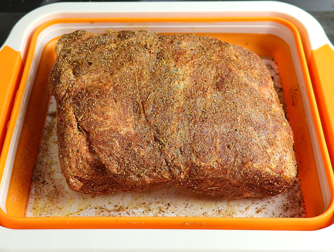 Pork butt expertly coated in mustard and adorned with a flavorful dry rub, ready to undergo a delicious transformation in the smoker.