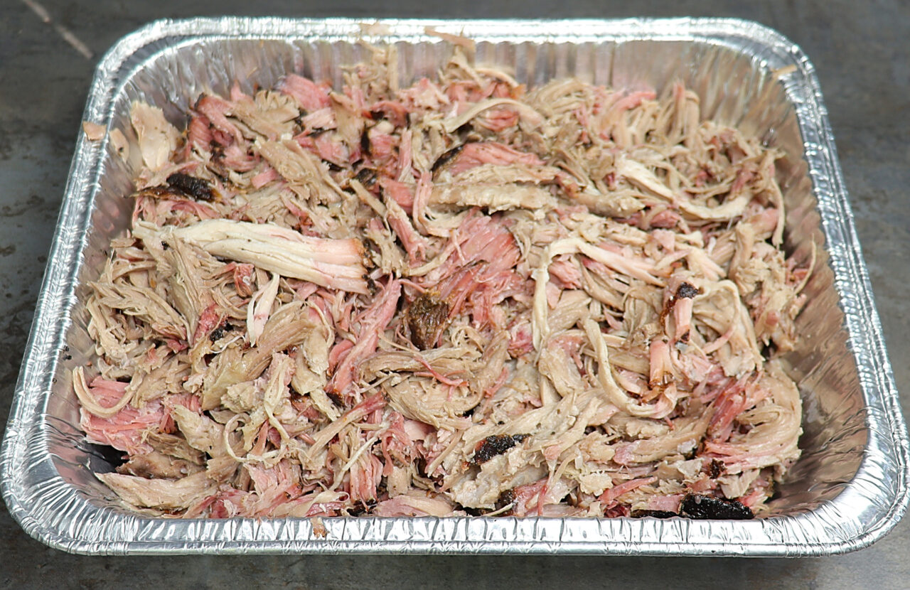 Smoked Pulled pork perfection: Tender strands of smoky goodness, a testament to slow smoking and flavorful expertise, ready to elevate your culinary creations.