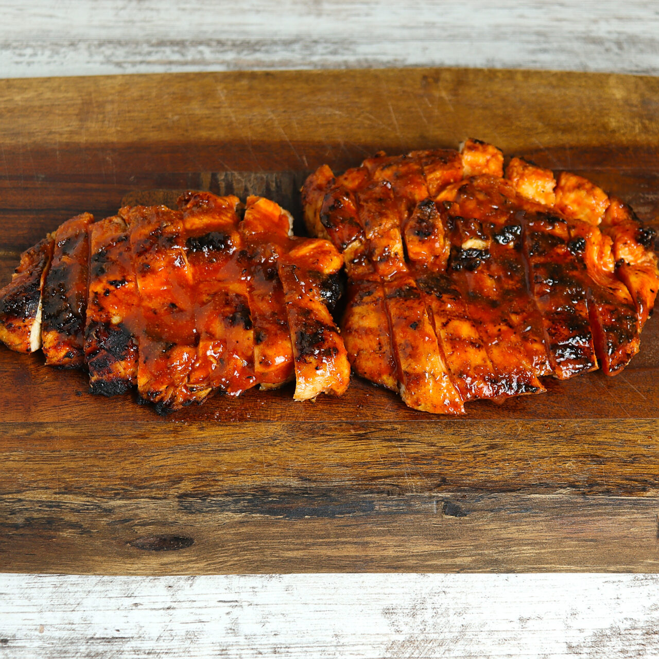 Sliced grilled buffalo chicken showcasing charred perfection, with a tantalizing blend of smoky and spicy flavors.