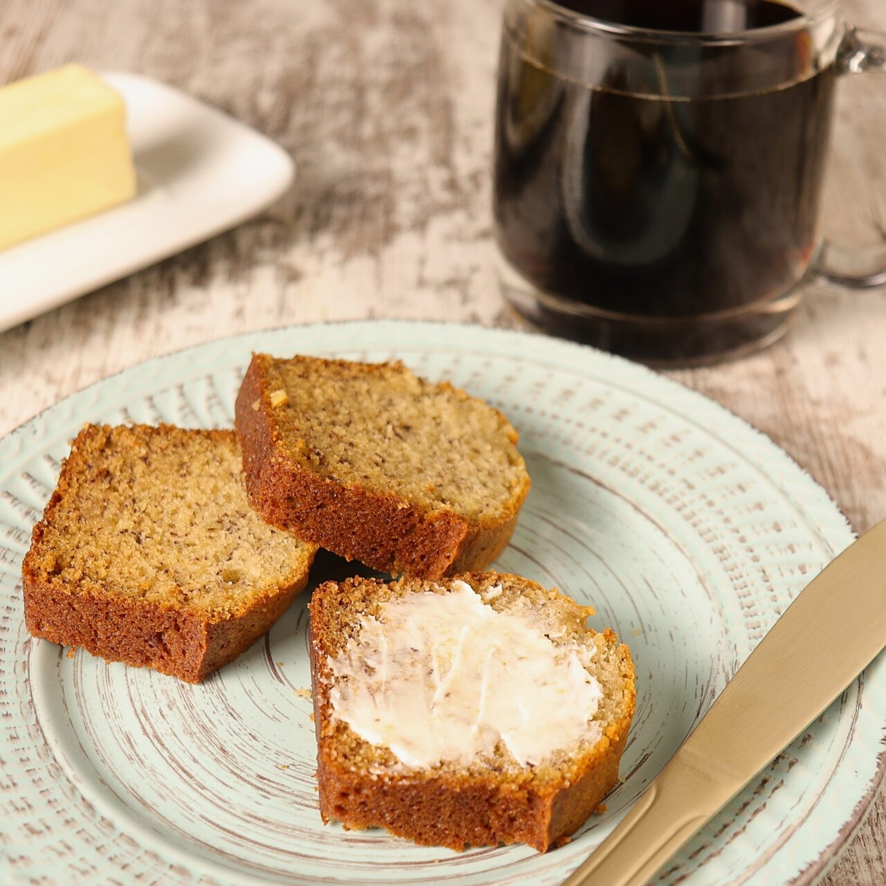 warm sliced banana bread with a cup of coffee.