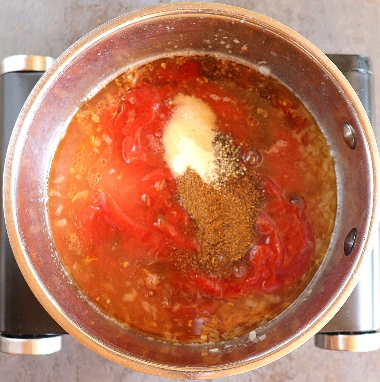 Adding ketchup, apple cider vinegar, brown sugar, chili powder, garlic powder, Worcestershire sauce, and other spices to the sautéed onions to create homemade BBQ sauce.